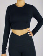 Front view of a woman wearing a black long sleeve crop tee